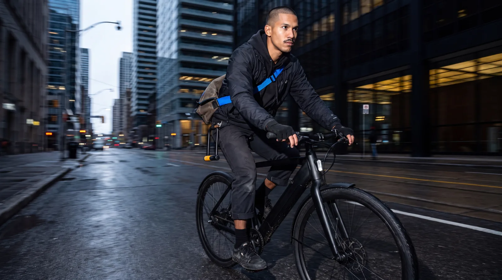A rider on a commuter e-bike moving through a city bike lane at speed