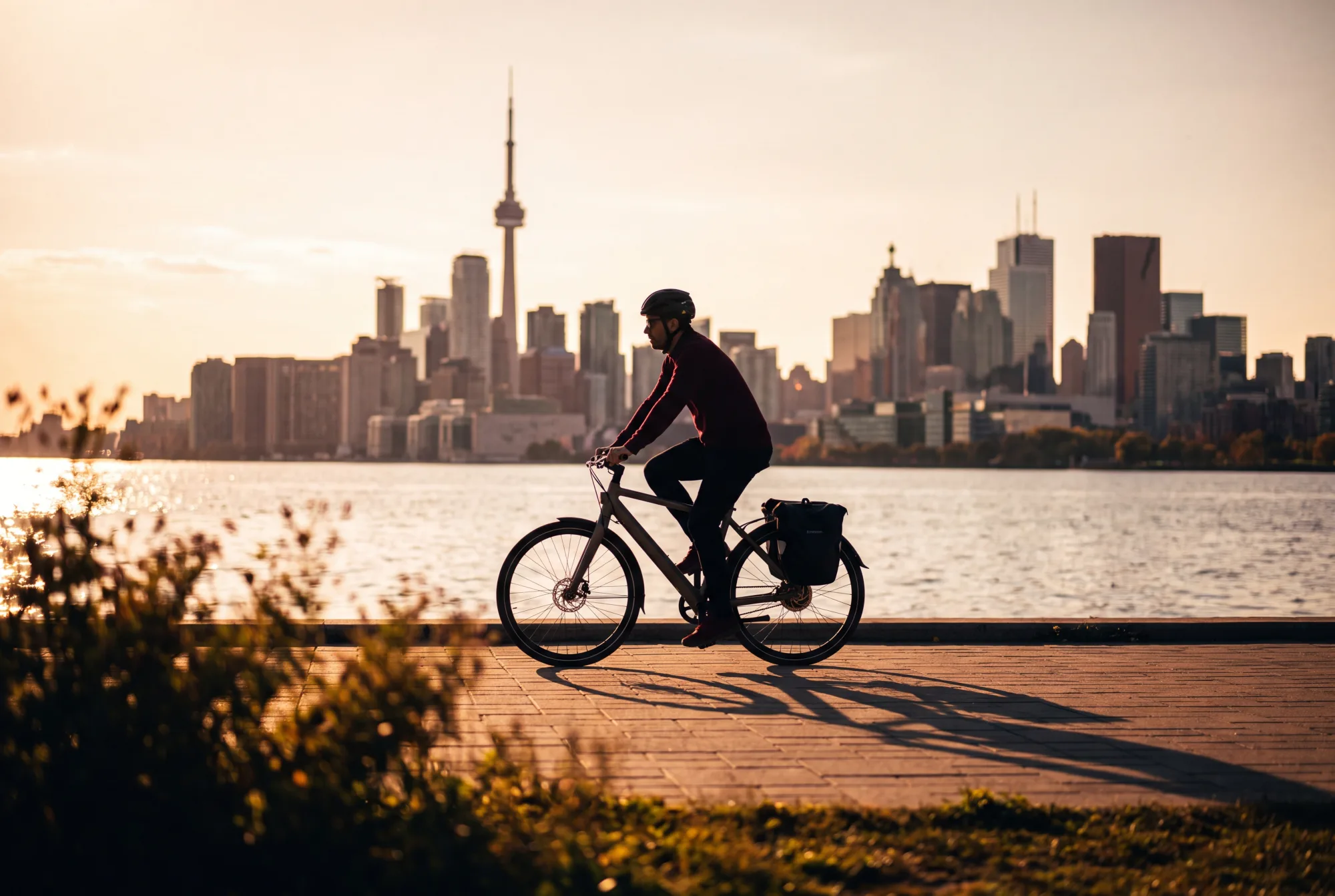 A cyclist on an e-bike in a Canadian city at golden hour